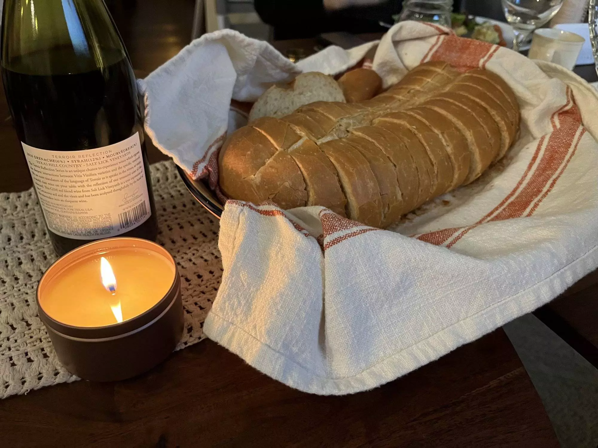Angled View of a Bread Loaf, wine and a candle.