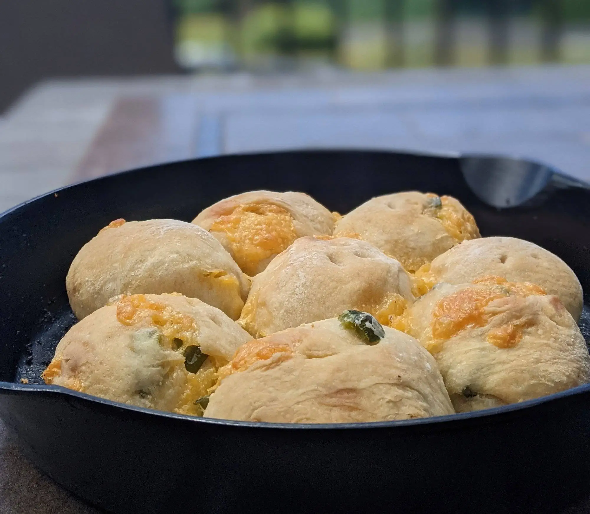 Angled View of Jalapeno Cheddar Sourdough Bread Rolls in a Cast Iron Pan.