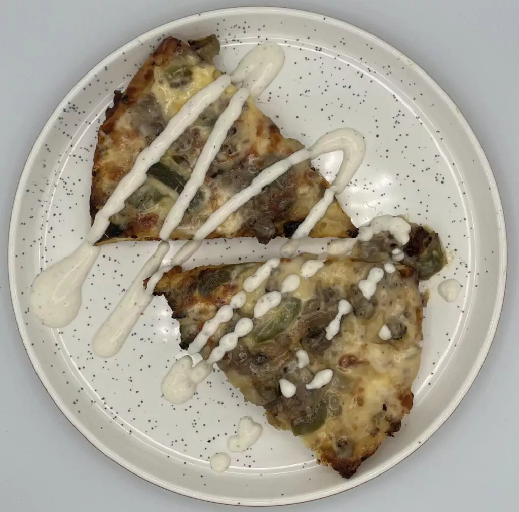 Cooked Pizza Slides on a plate topped with Ranch dressing.