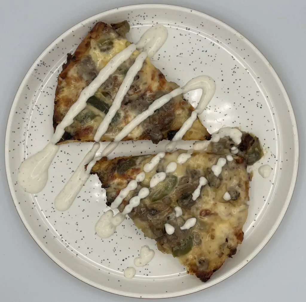 Cooked Pizza Slides on a plate topped with Ranch dressing.
