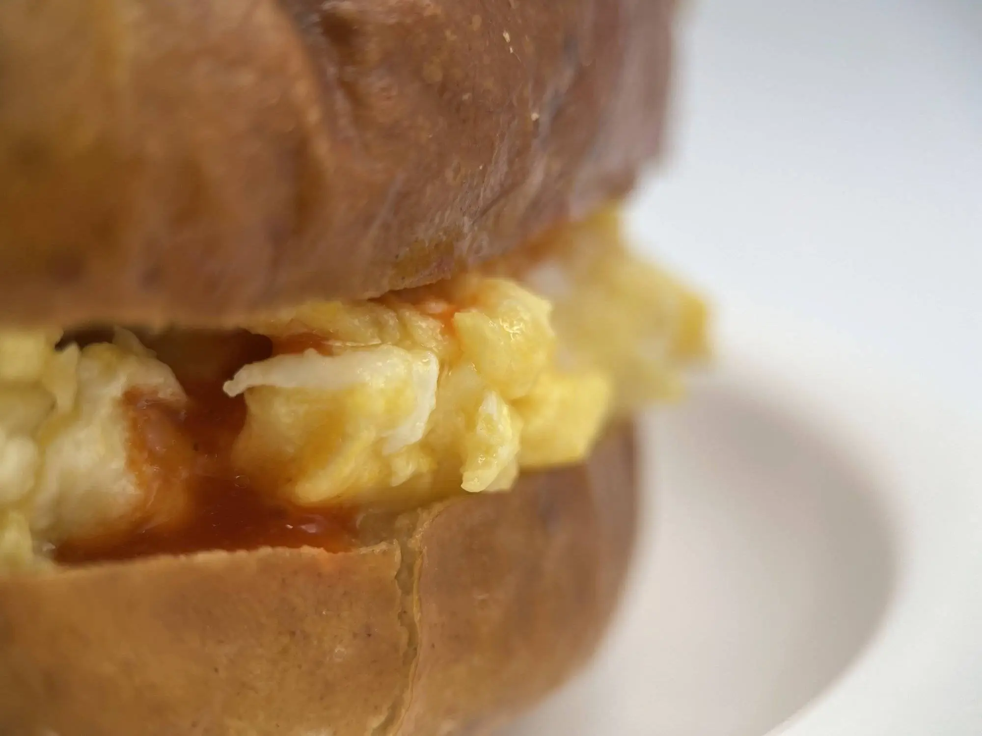 Side view of a breakfast egg pretzel bun sandwich