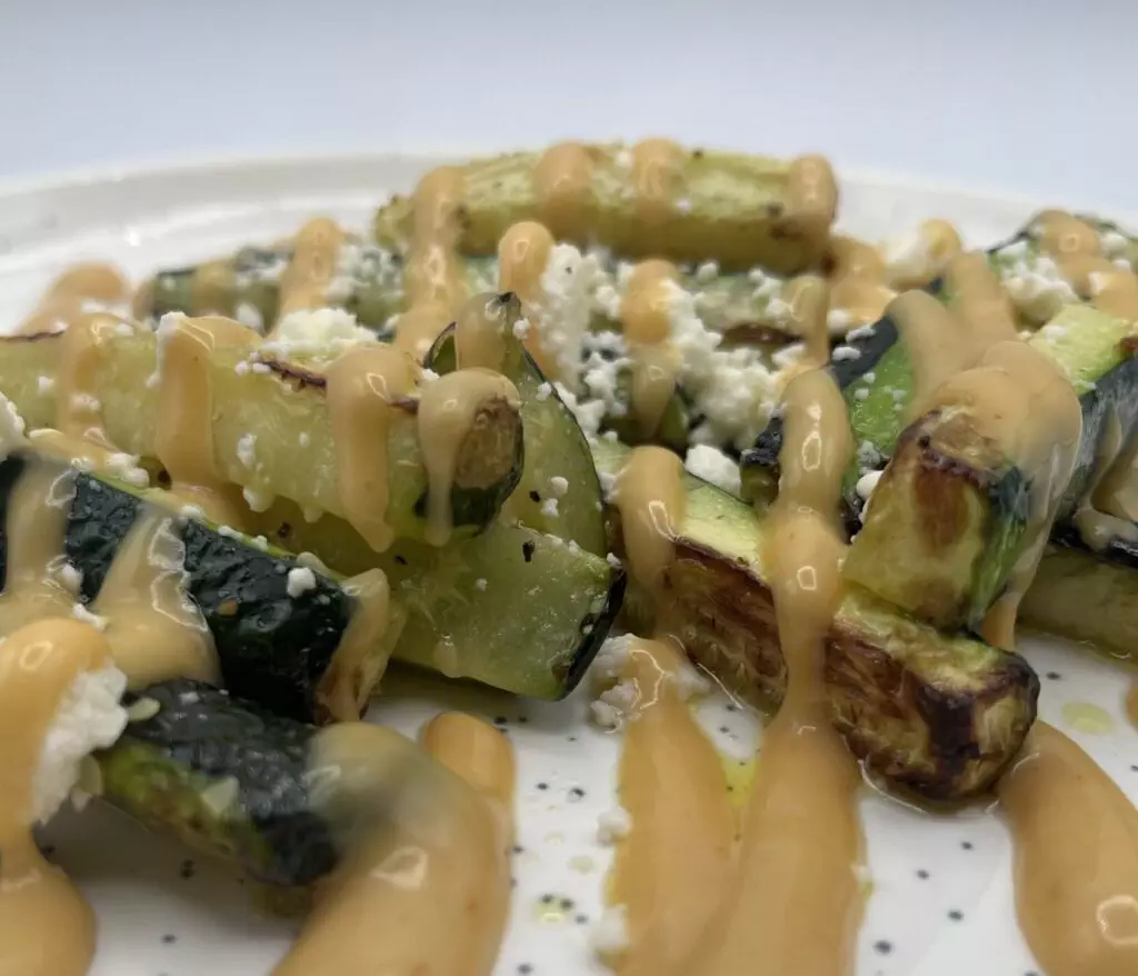 Close-up of Zucchini fries with crumbly cheese and ChickFilA sauce.