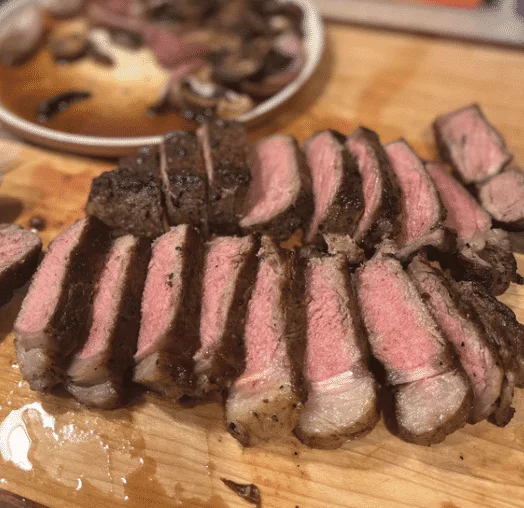 Side View of medium well Ribeye steak cut into bite sized strips